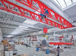 The Demag process crane lifting an aluminium coil with a hook.