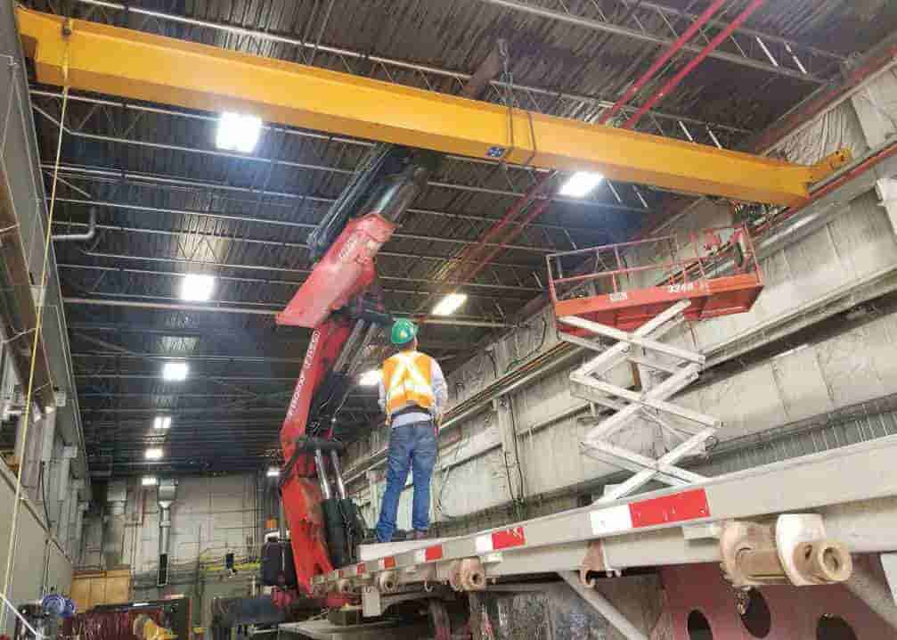 Overhead Crane Solutions installing a crossbeam in tight quarters using a Fassi F1500XP articulating crane.